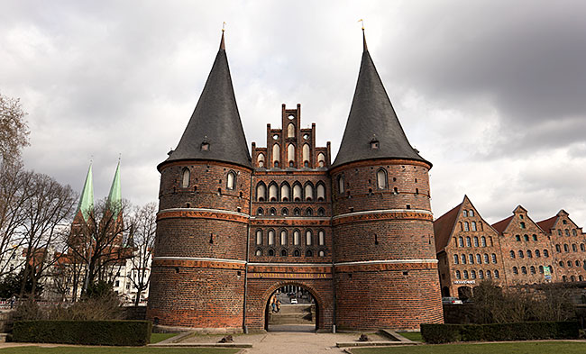 The most popular photo motif in Lübeck: the Holstentor. To the right are historic salt warehouses; to the left in the background stand the towers of St. Mary's Church - Bremen sehenswert - distant places